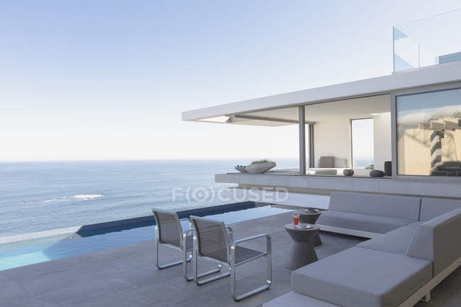 Moderne, maison de luxe vitrine patio extérieur avec piscine et vue sur l'océan — Photo de stock