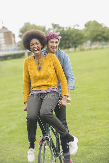 Couple riding bicycle together in park — Stock Photo