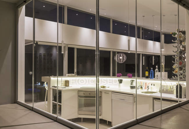 Illuminato moderno lusso casa vetrina cucina interna di notte — Foto stock