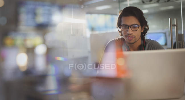Focused businessman working at laptop in office — Stock Photo