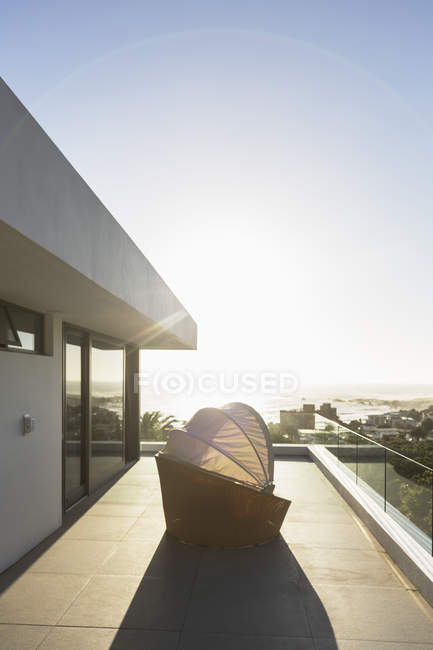 Крытый стул патио на солнечном современном роскошном балконе под голубым небом — стоковое фото