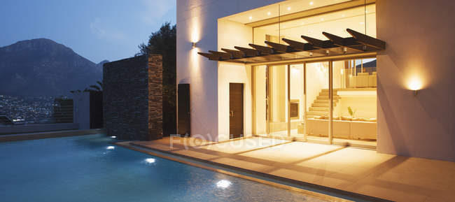 Beleuchtetes modernes Haus mit Blick auf Schwimmbad — Stockfoto