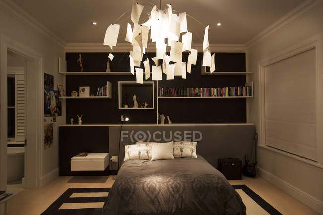 Illuminated modern paper chandelier hanging in bedroom — Stock Photo