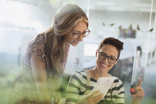 Lächelnde kreative Geschäftsfrauen mit Prototyp mit digitalem Tablet — Stockfoto