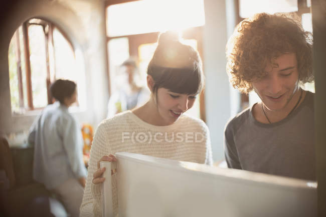 Young couple opening refrigerator in kitchen — Stock Photo