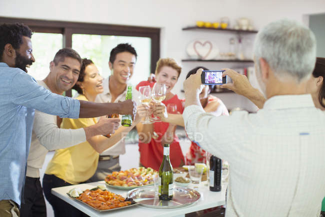 Man taking picture of friends at party — Stock Photo