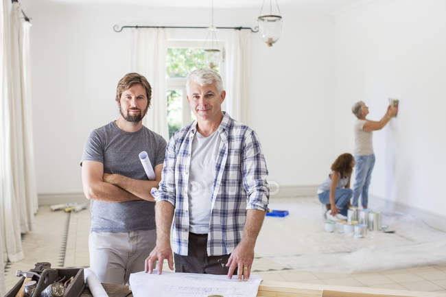 Father and son looking through construction plans — Stock Photo
