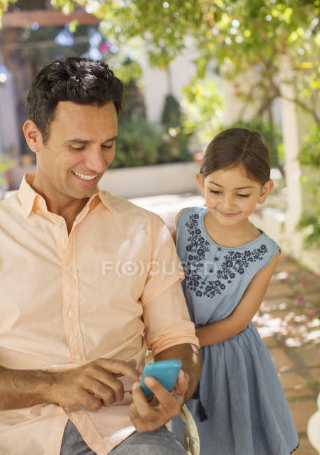 Vater und Tochter schauen aufs Handy — Stockfoto