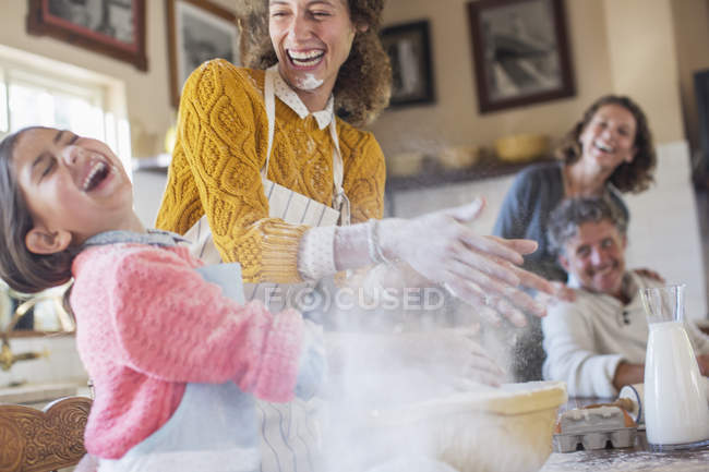 Mãe e filha brincando com farinha na cozinha — Fotografia de Stock