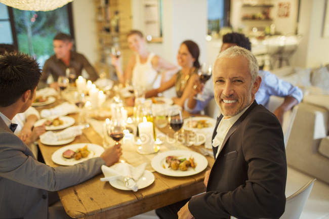 Mann lächelt bei Dinnerparty — Stockfoto