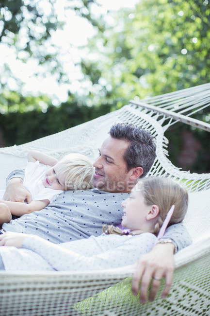 Батько і діти відпочивають в гамаку — стокове фото