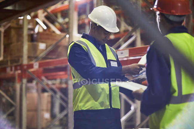 Workers with clipboards meeting in distribution warehouse — Stock Photo