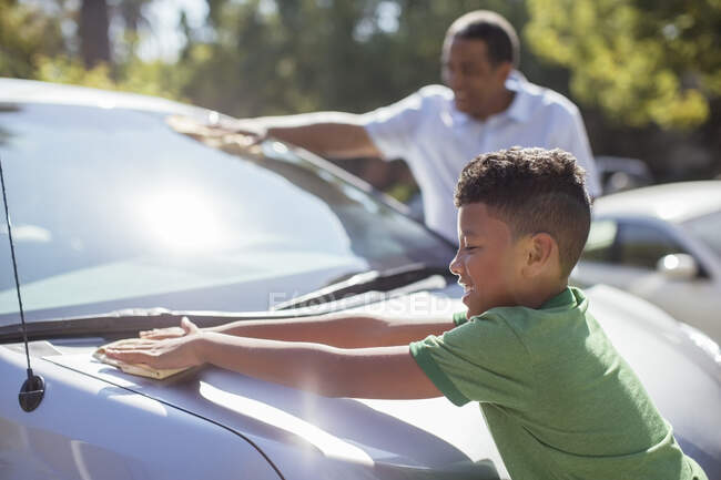 Grandfather and grandson wiping car — Stock Photo