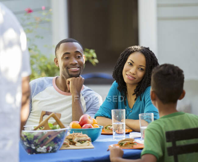 Famiglia che mangia pranzo al tavolo patio — Foto stock