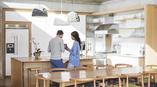 Пара с помощью цифрового планшета на кухне — стоковое фото