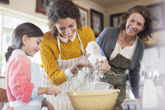 Tres generaciones de mujeres horneando juntas - foto de stock