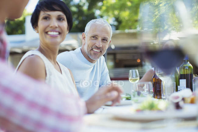 Casal sorrindo à mesa ao ar livre — Fotografia de Stock