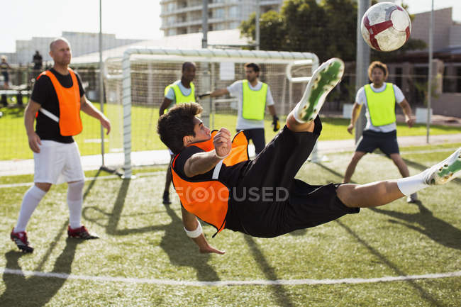 Fußballer trainieren Tricks auf sonnigem Platz — Stockfoto