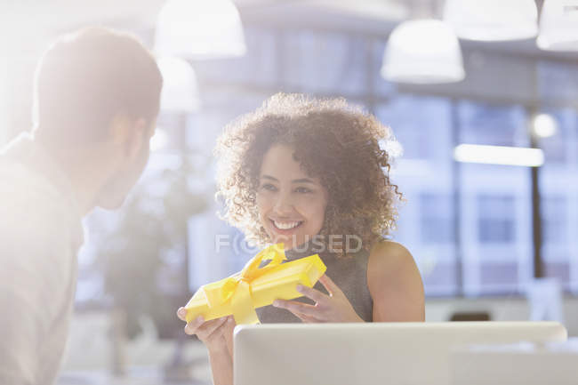 Бізнес-леді тримає подарунок в офісі — стокове фото