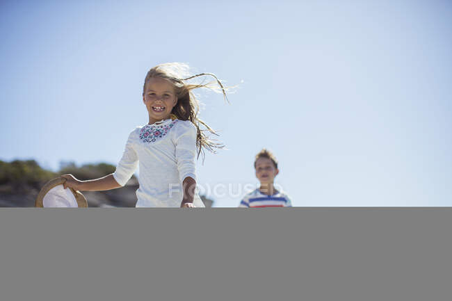 Giovane ragazza e ragazzo in esecuzione lungo la spiaggia — Foto stock