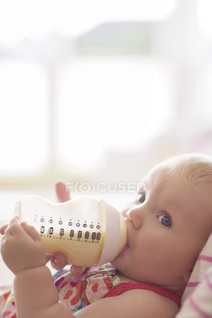 Baby girl drinking from bottle — Stock Photo