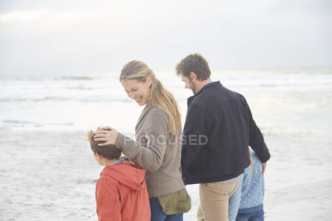 Sorridente passeggiata in famiglia sulla spiaggia invernale — Foto stock