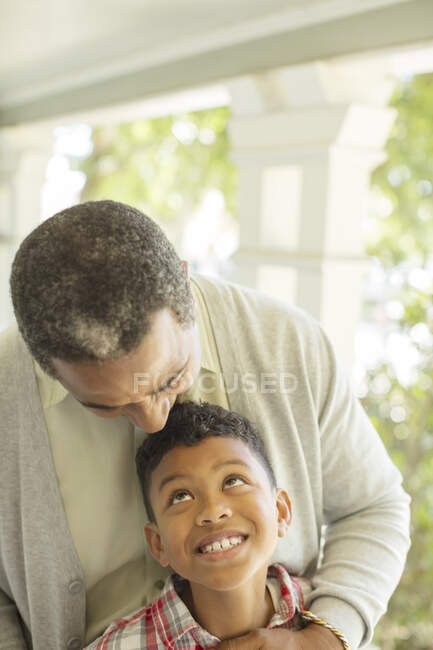 Grandfather hugging grandson on porch — Stock Photo