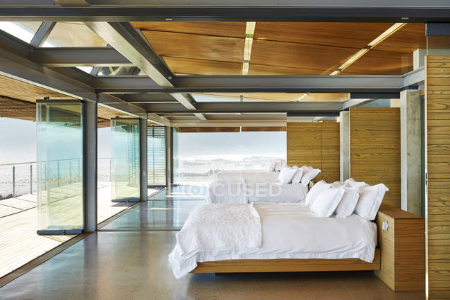 Modern hotel beds in a row open to patio — Stock Photo
