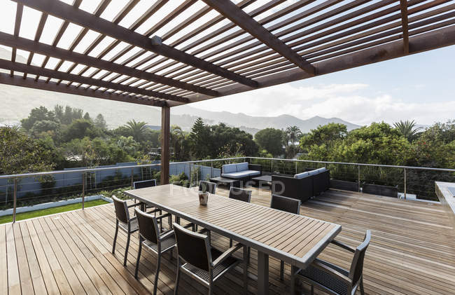 Maison de luxe vitrine extérieure patio en bois et table avec vue sur la montagne — Photo de stock