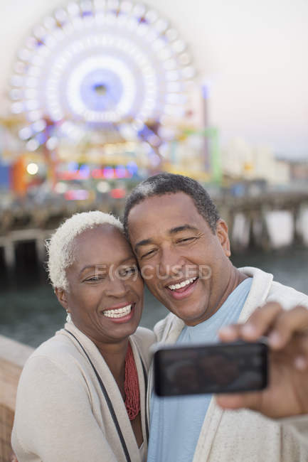 Coppia anziana scattare selfie al parco divertimenti — Foto stock