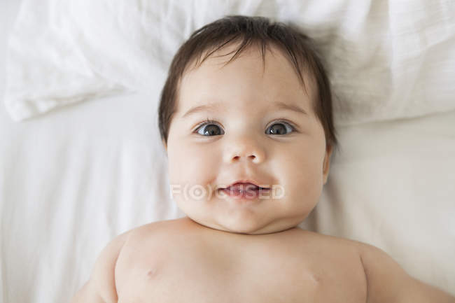 Adorable bébé fille couché sur le lit — Photo de stock