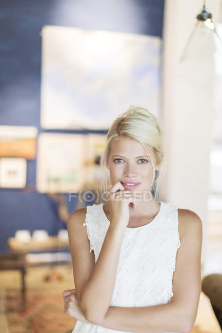 Mujer sosteniendo su barbilla en la mano - foto de stock