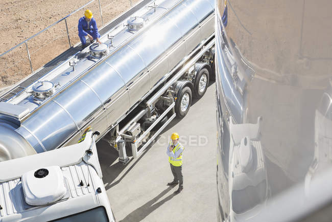 Workers around stainless steel milk tanker — Stock Photo
