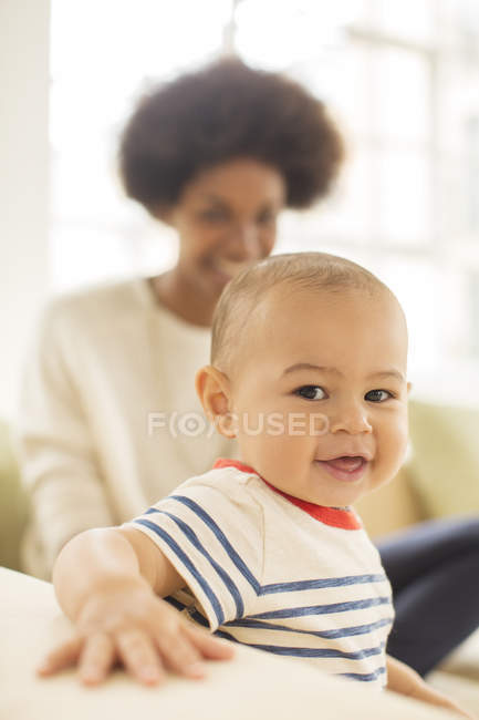 Mère et bébé garçon assis sur le canapé à la maison — Photo de stock