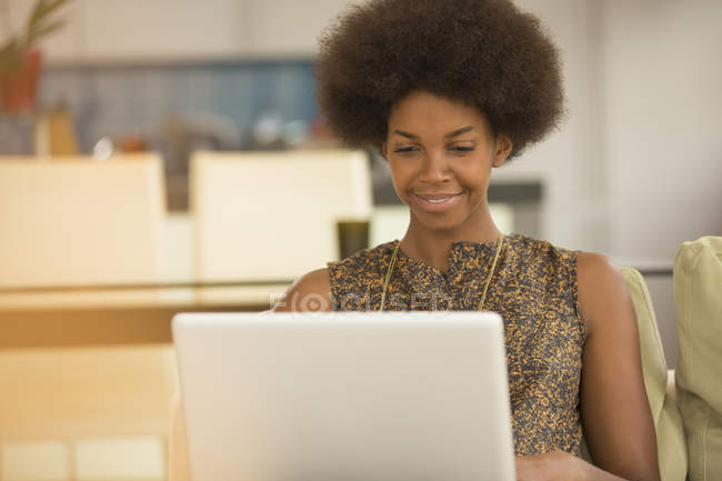 Lächelnde Geschäftsfrau mit Laptop im Büro — Stockfoto