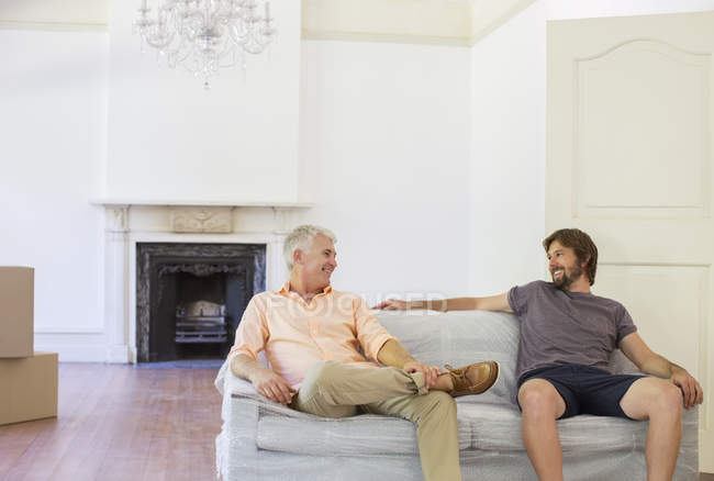 Father and son sitting on couch in living space — Stock Photo