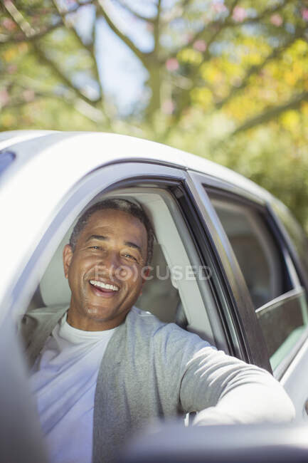 Портрет пожилого человека, смеющегося в машине — стоковое фото