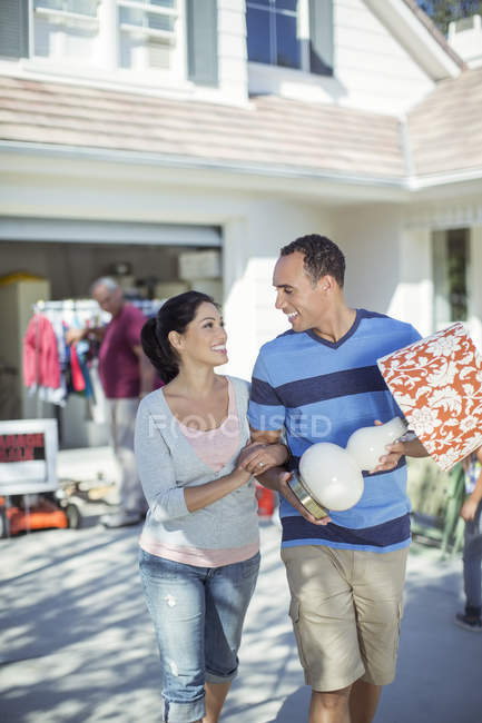 Счастливая пара покупает лампу на дворовой распродаже — стоковое фото