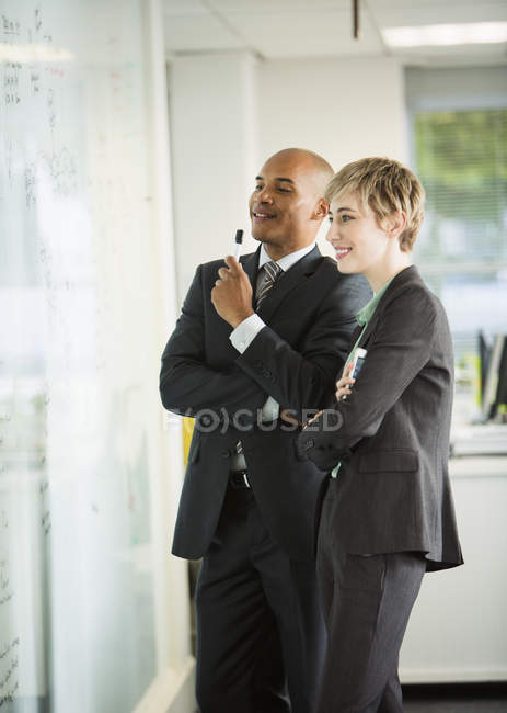 Uomini d'affari che guardano lavagna bianca in ufficio — Foto stock