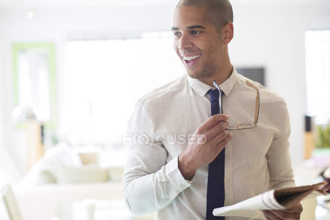 Businessman holding newspaper in kitchen at home — Stock Photo