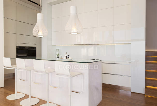 Bar stools at counter in modern kitchen — Stock Photo