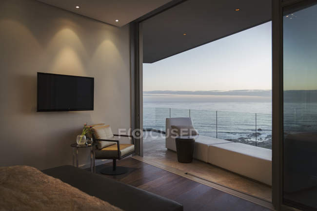 Tranquillo crepuscolo vista sull'oceano oltre moderno lusso casa vetrina balcone — Foto stock