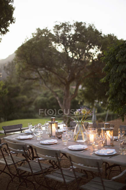 Lanternes éclairées sur table de patio tranquille — Photo de stock