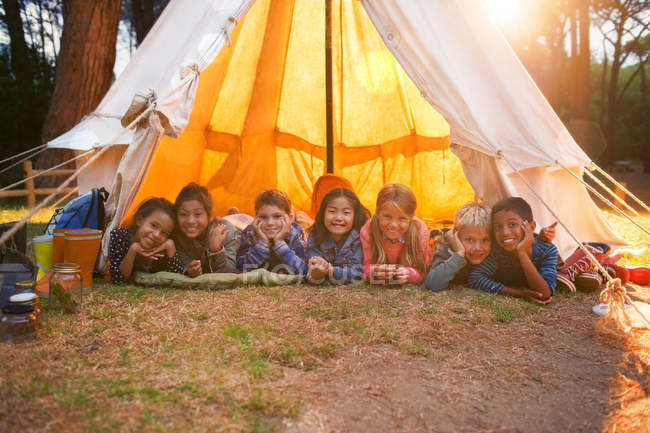 Children smiling in teepee at campsite — Stock Photo