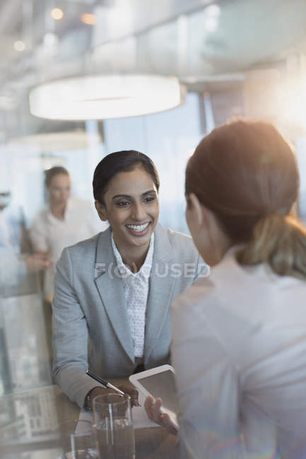 Donne d'affari sorridenti che utilizzano tablet digitali in ufficio — Foto stock