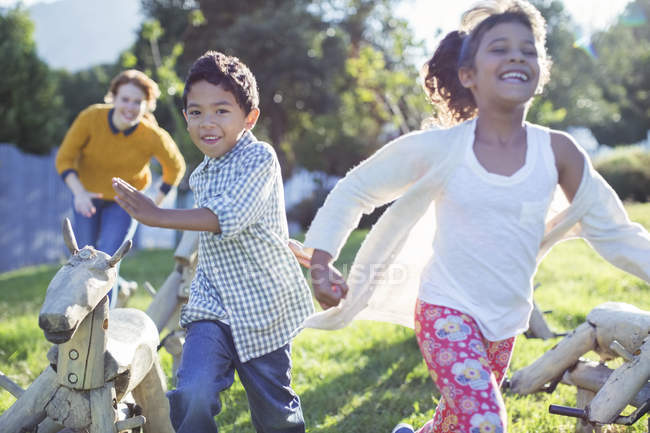 Crianças correndo no campo sobre a grama — Fotografia de Stock