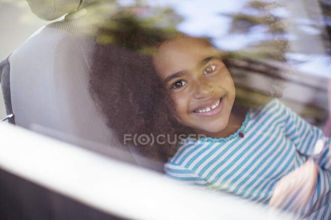 Retrato de chica feliz en el asiento trasero del coche - foto de stock
