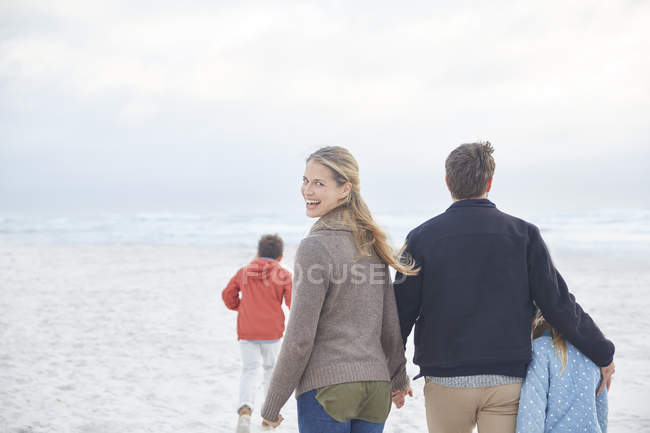 Portrait happy family walking on winter beach — Stock Photo