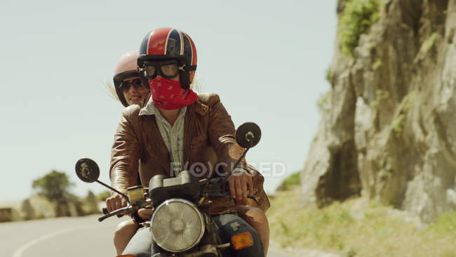 Jovem casal equitação motocicleta na estrada ensolarada — Fotografia de Stock