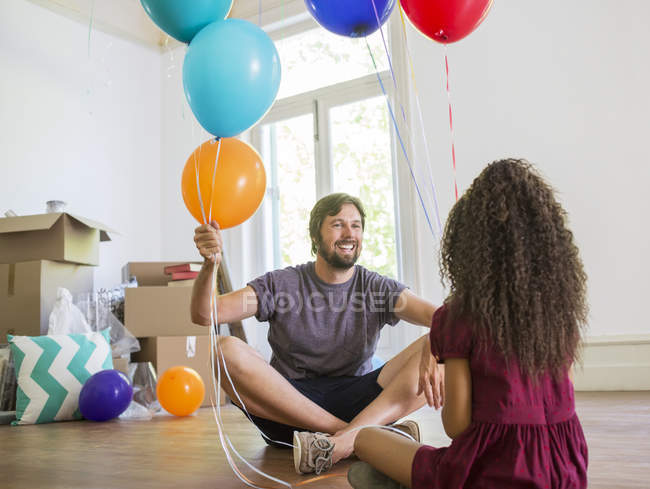 Padre e hija jugando con globos - foto de stock